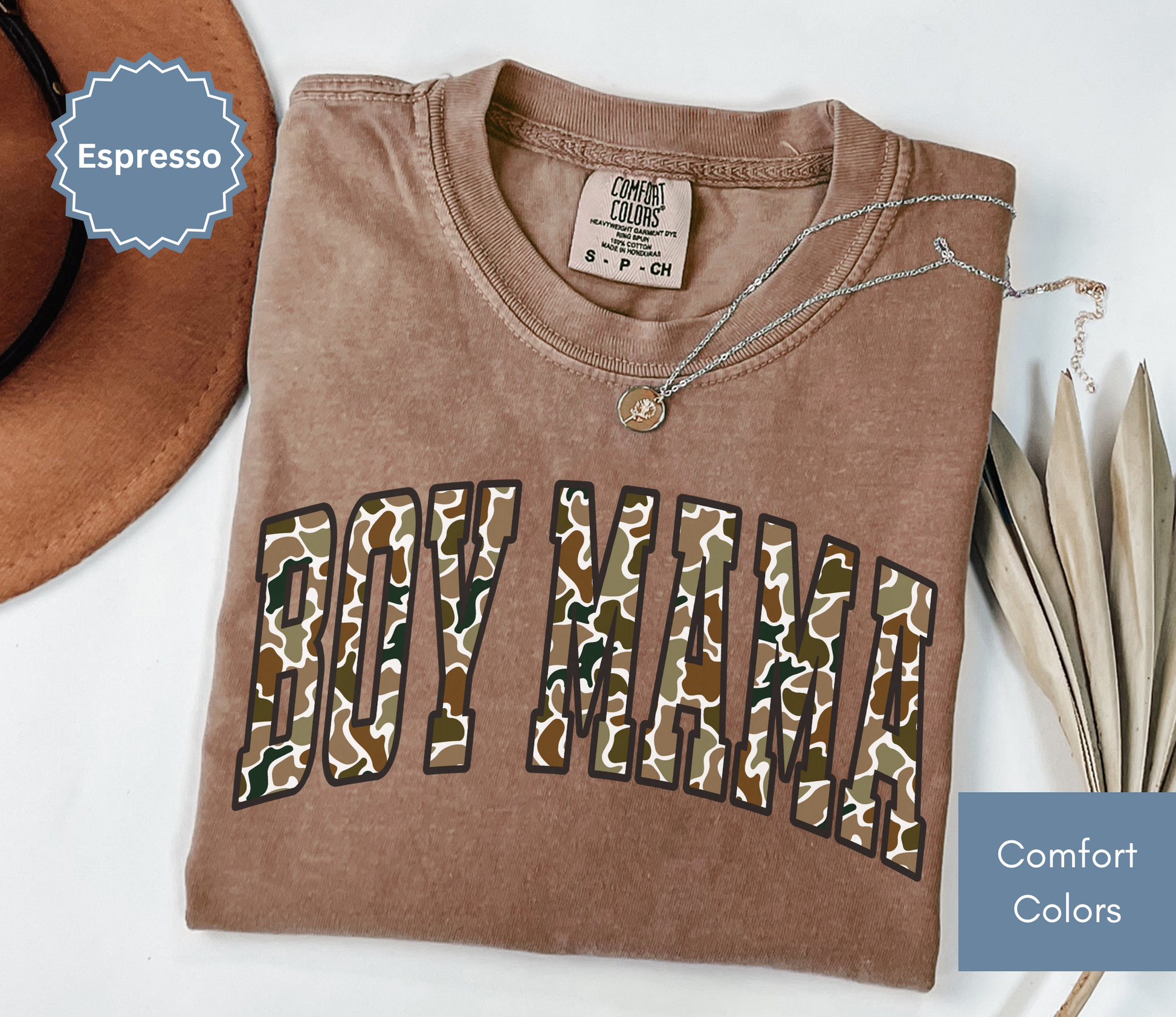 Folded brown shirt with camouflage "BOY MAMA" text design.