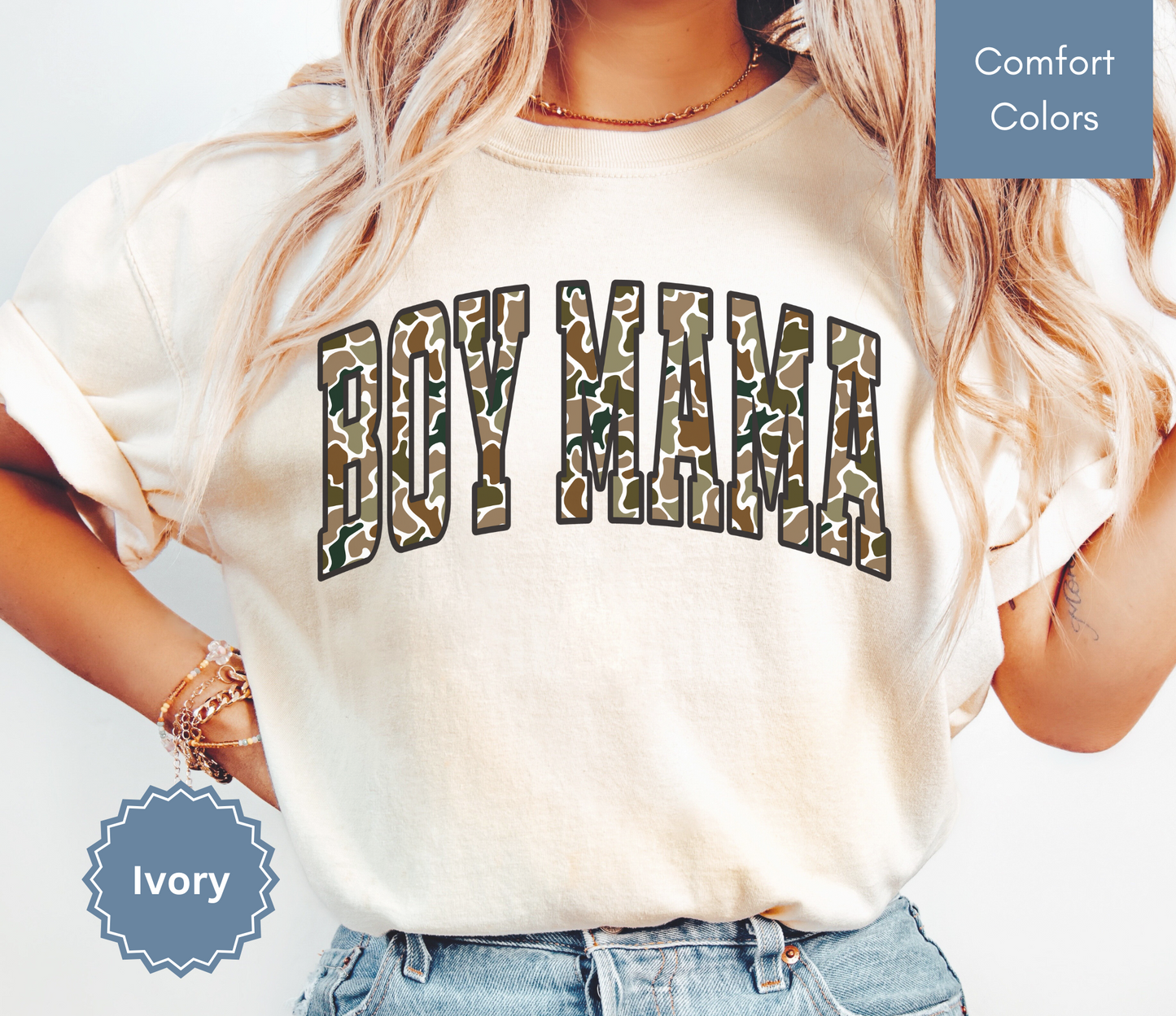 Woman wearing an ivory shirt with camouflage "BOY MAMA" text design.
