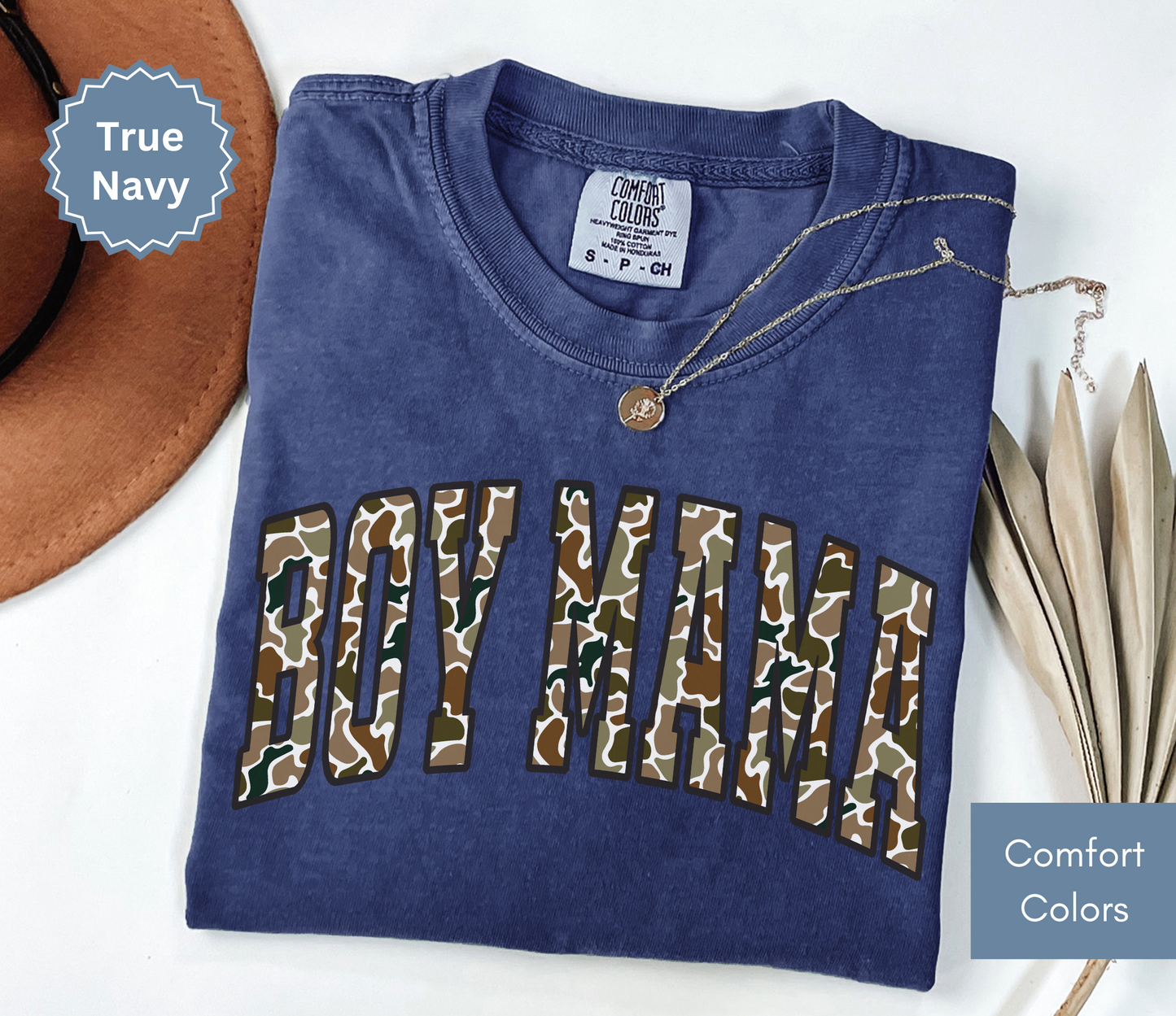 Folded navy blue shirt with camouflage "BOY MAMA" text design.