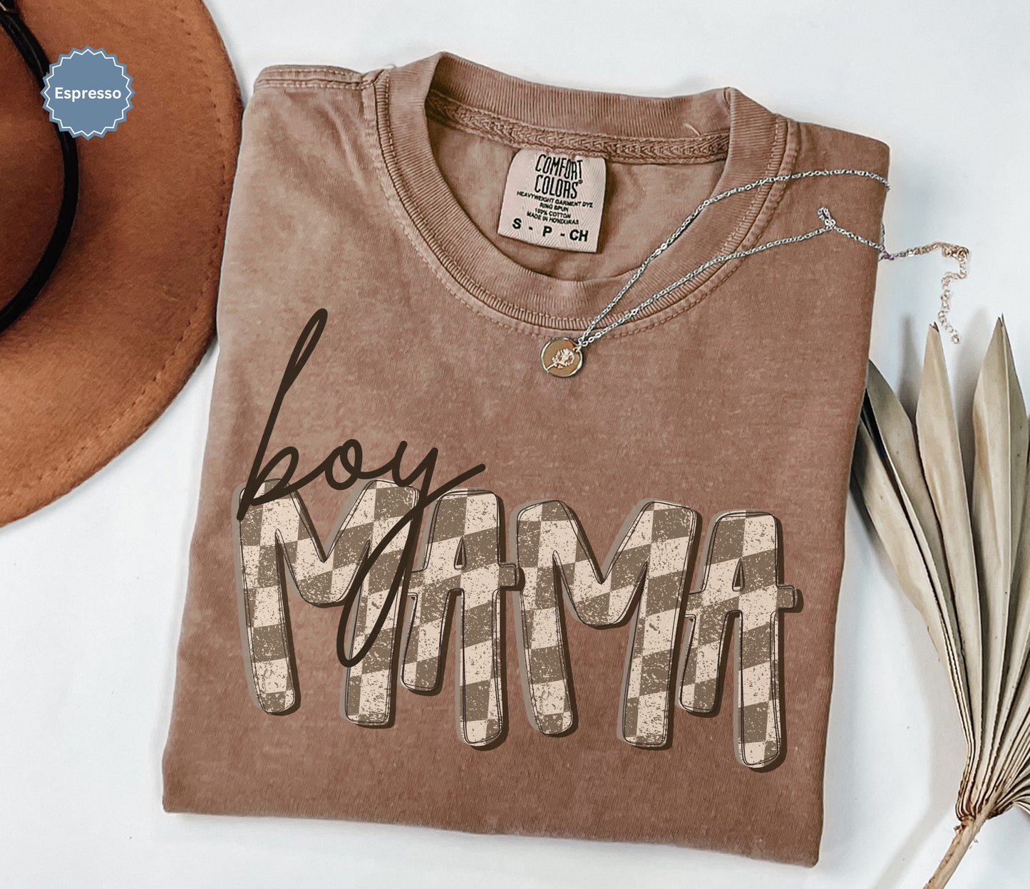 Folded espresso brown comfort colors t-shirt with retro checkered 'BOY MAMA' text.