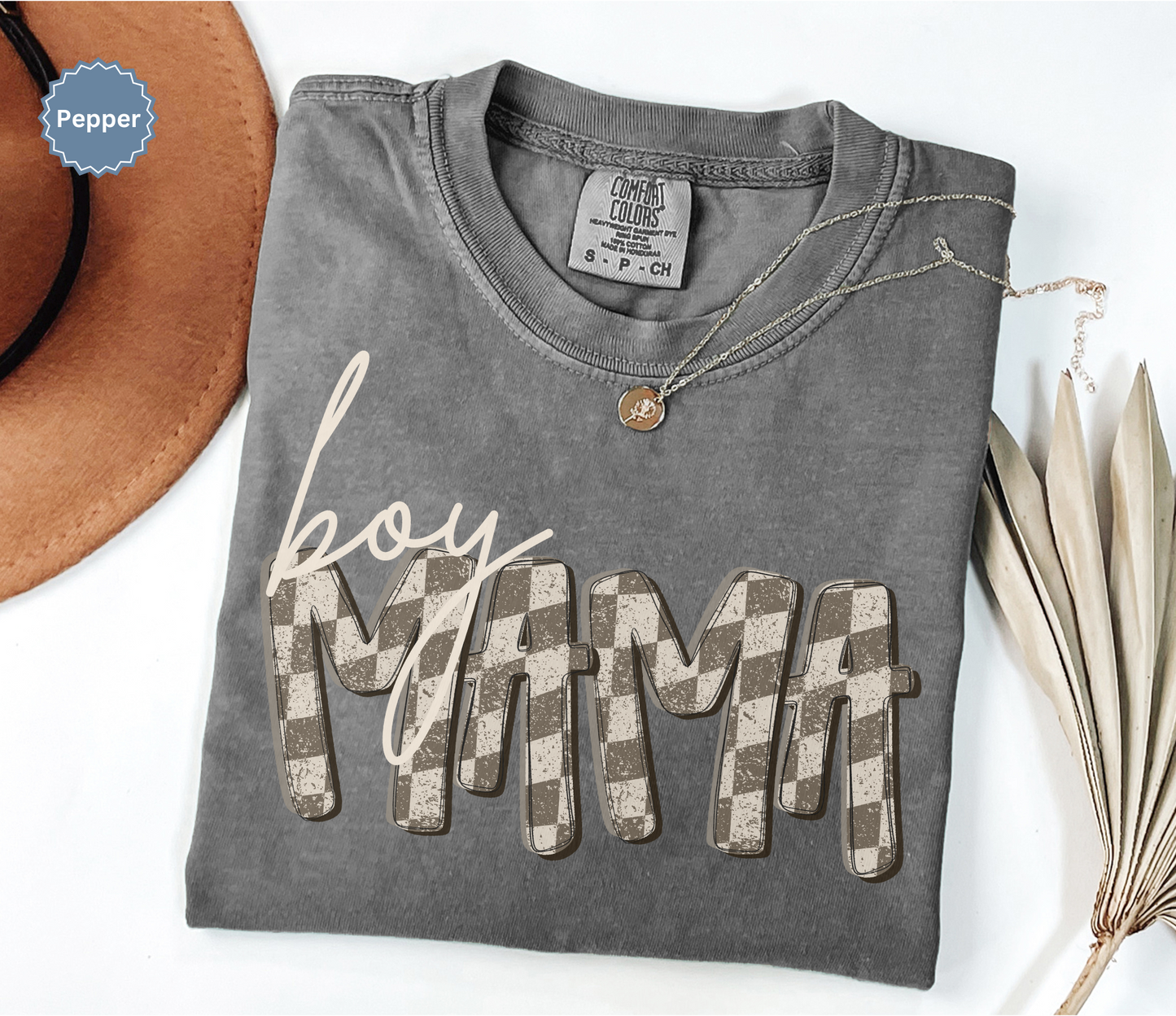 Folded dark gray comfort colors t-shirt with retro checkered 'BOY MAMA' text.
