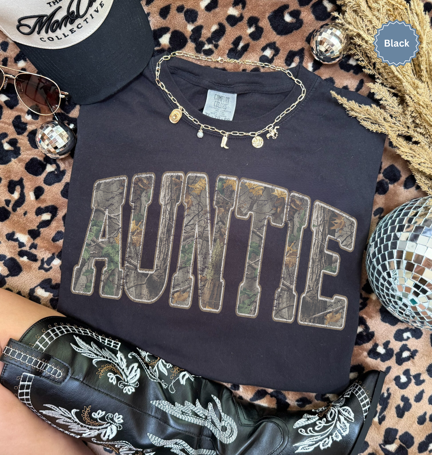 Folded comfort colors Black t-shirt with 'AUNTIE' printed in distressed camo.