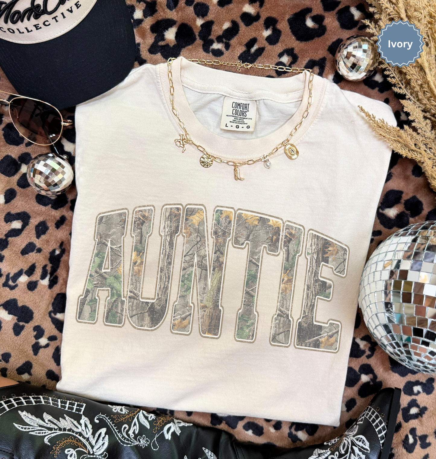 Folded comfort colors ivory t-shirt with 'AUNTIE' printed in distressed camo.