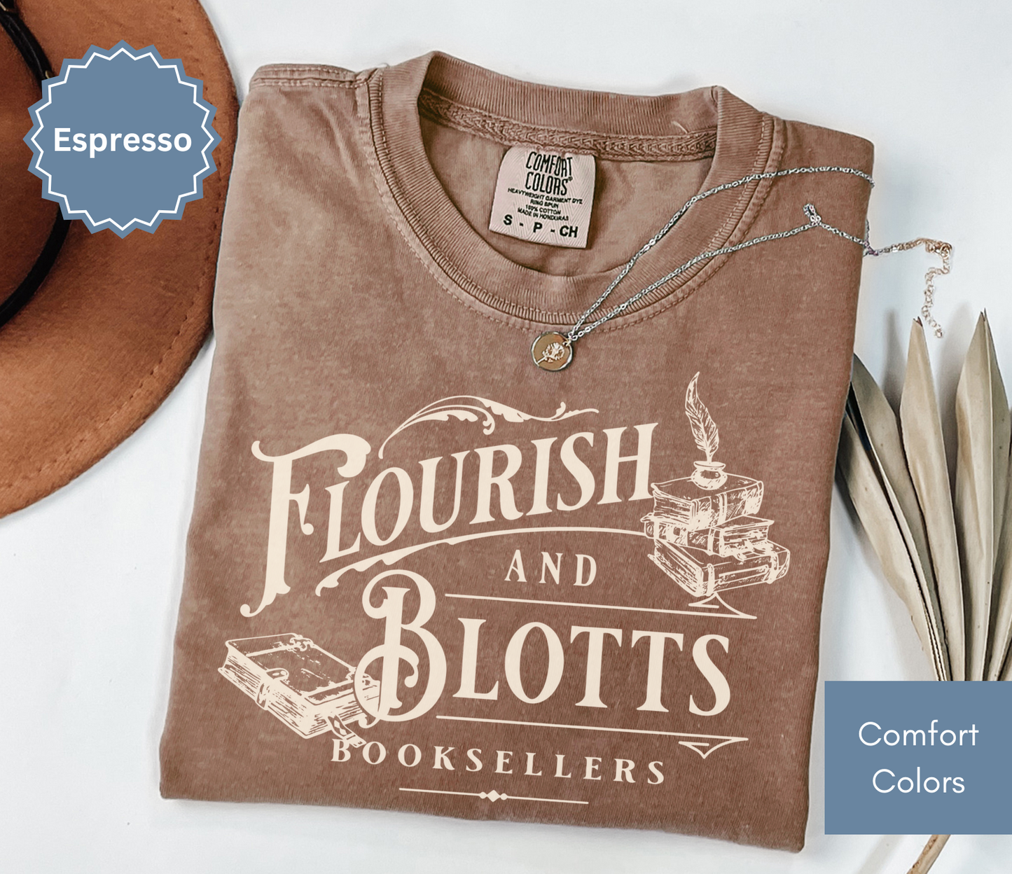 Folded espresso brown comfort colors t-shirt with 'Flourish and Blotts Booksellers' design on a white background.