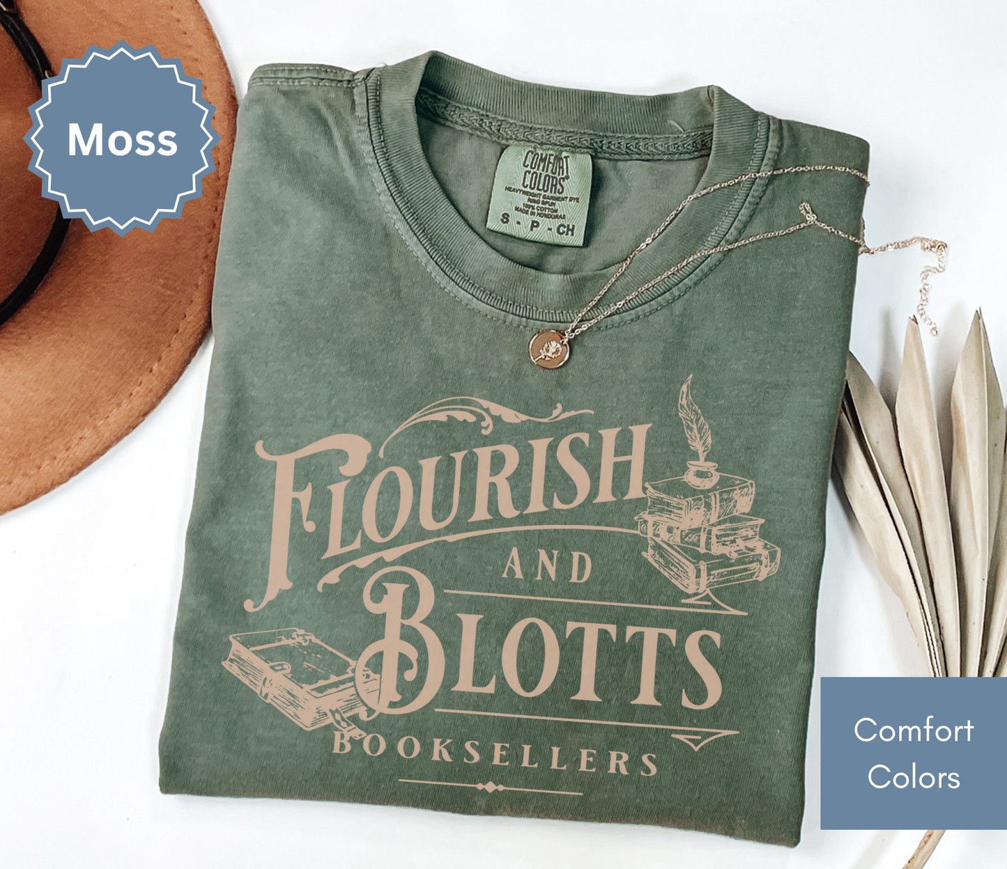 Folded moss green comfort colors t-shirt with 'Flourish and Blotts Booksellers' design on a white background.