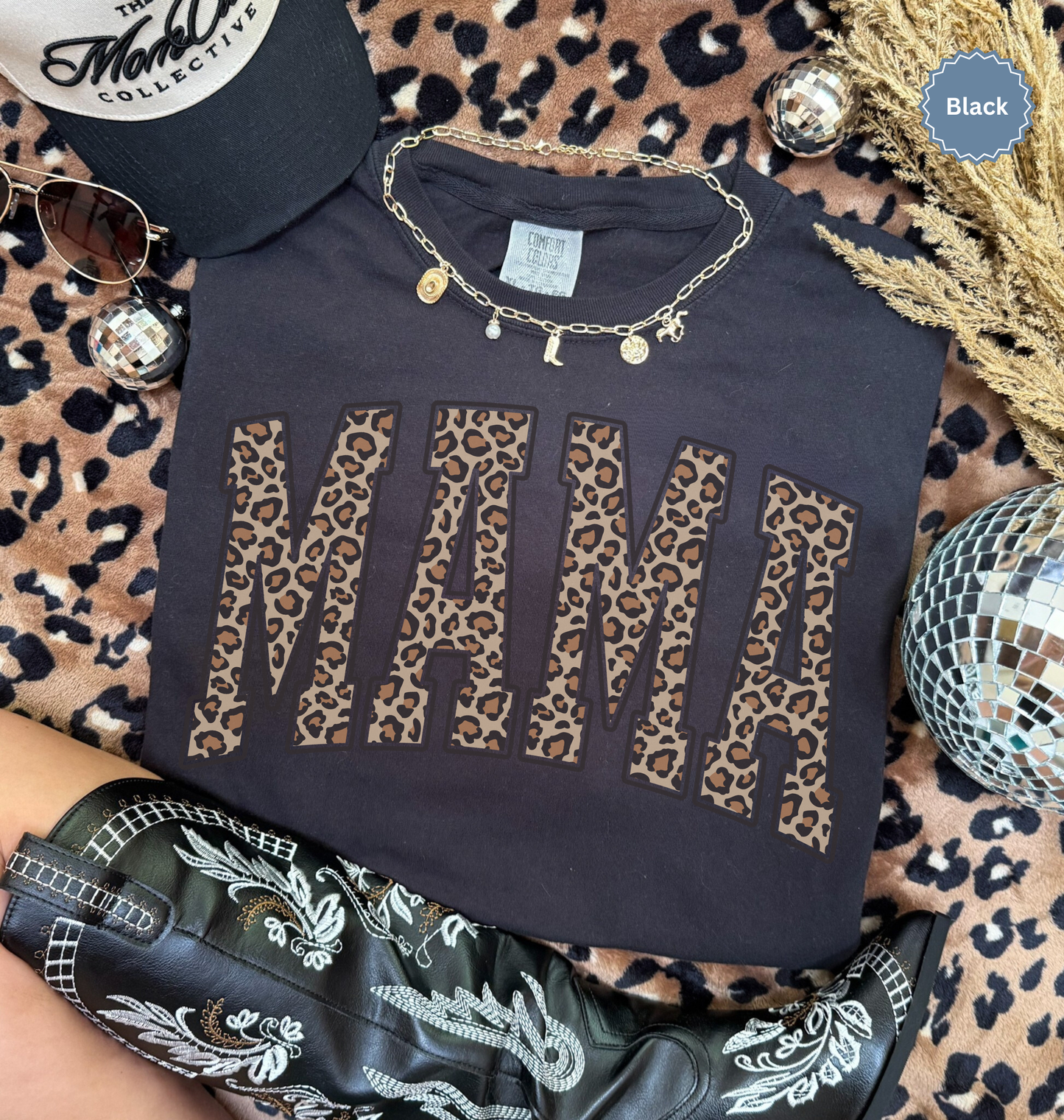 Folded black comfort colors t-shirt with 'MAMA' in leopard print.