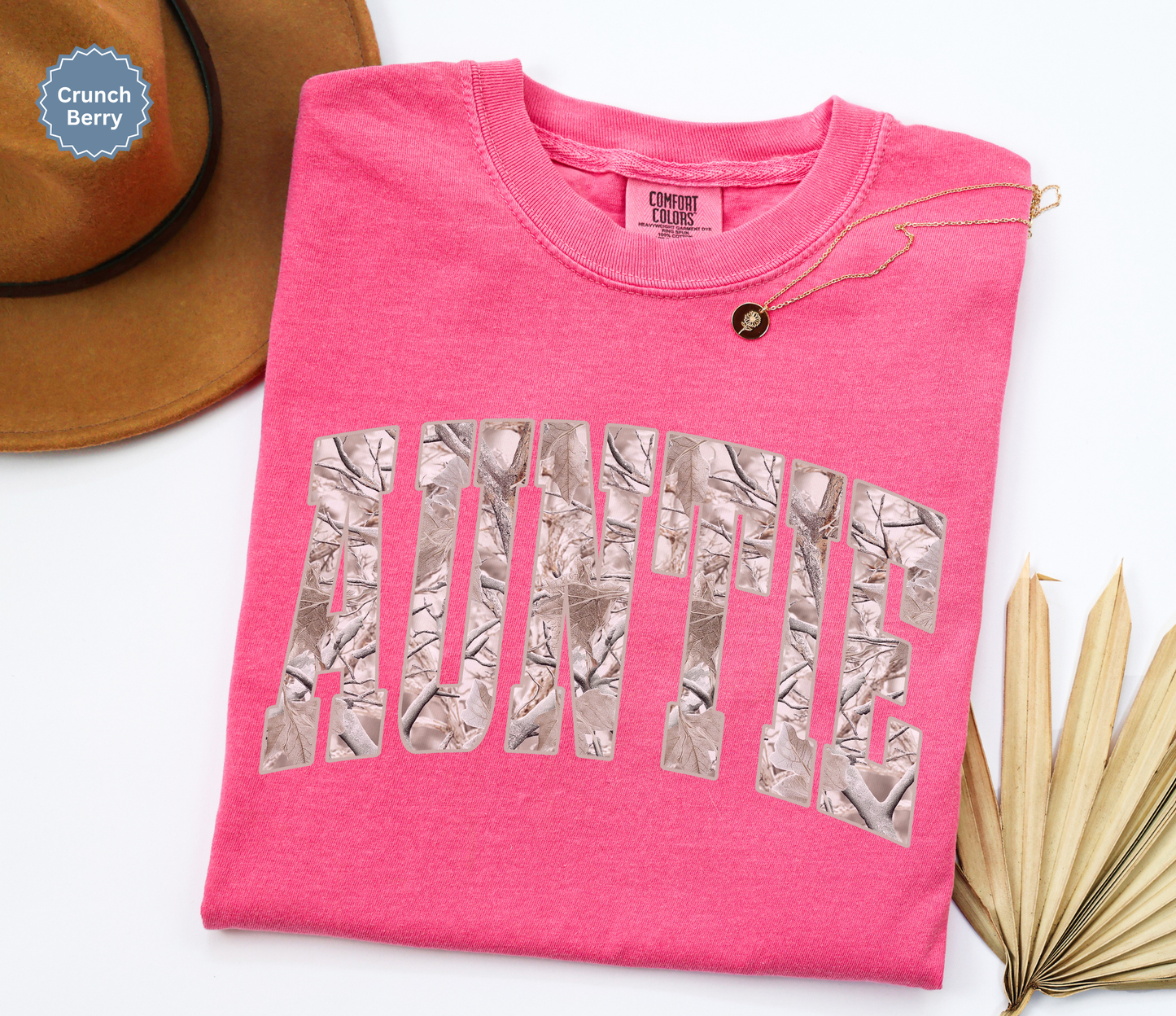 Folded comfort colors crunchberry t-shirt with 'Auntie' printed in a snow camo pattern.