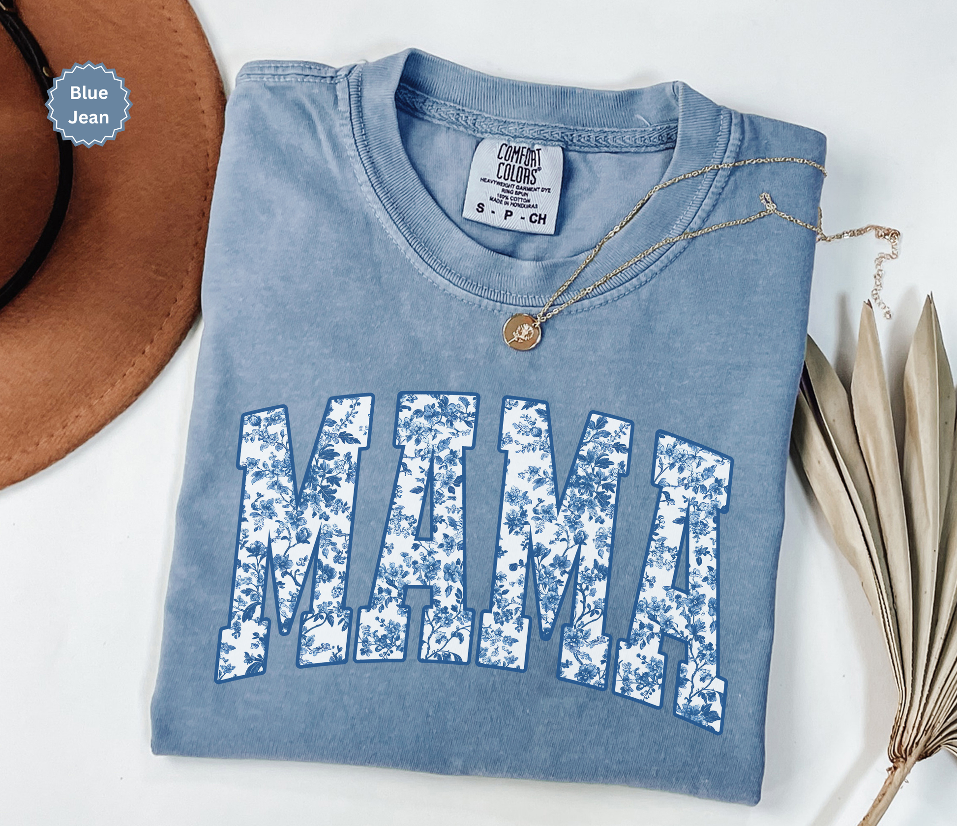 Folded blue jean colored t-shirt with 'MAMA' toile floral print design.