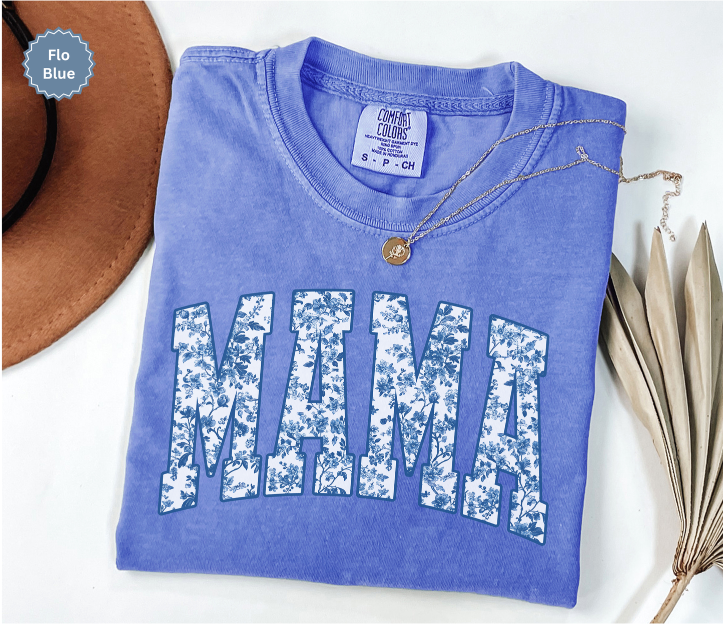 Folded blue t-shirt with 'MAMA' toile floral print design.