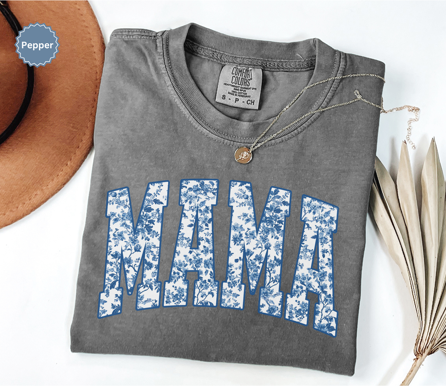 Folded dark grey t-shirt with 'MAMA' toile floral print design.