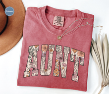 Load image into Gallery viewer, Comfort colors crimson red t-shirt with floral 'AUNT' varsity text
